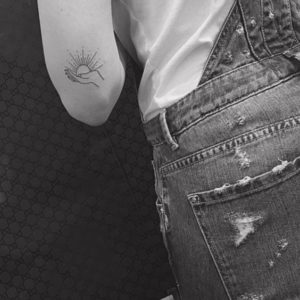 Tatuaje minimalista mano y sol