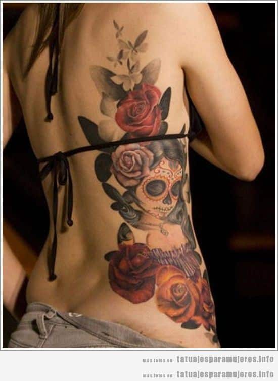 Tatuaje de rosas y calaveras mexicanas en la espalda de una mujer