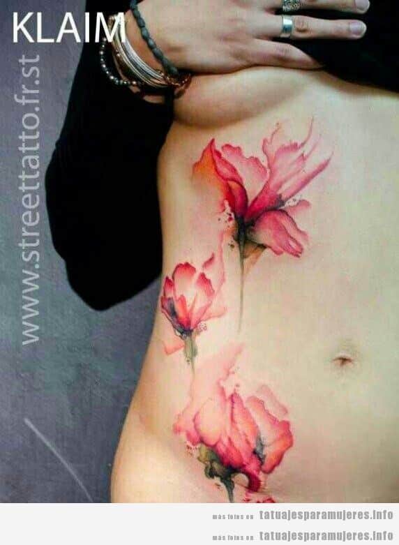 Tatuaje mujer, tres flores estilo acuarela en el tronco