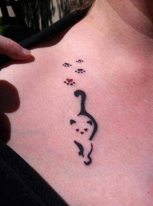 Tatuaje pequeño para mujer en el pecho, un gato
